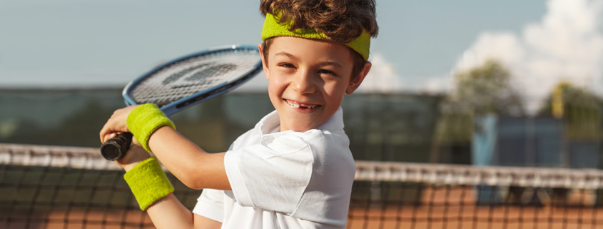 Tennis: glückliches Kind mit Schläger