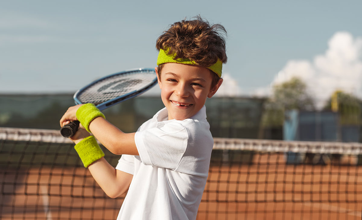 Tennis: glückliches Kind mit Schläger